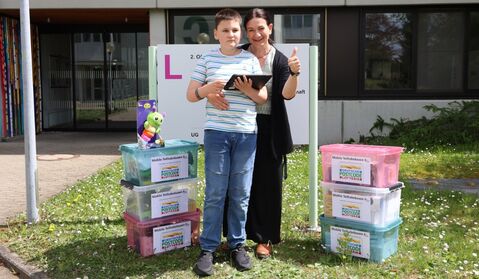 Ramona Biller aus dem Leitungsteam der UK-Beratungsstelle im Hegau-Jugendwerk freut sich gemeinsam mit einem jungen Patienten über die neuen Teilhabeboxen, die durch die großartige Förderung der Deutschen Postcode Lotterie realisiert werden konnten.